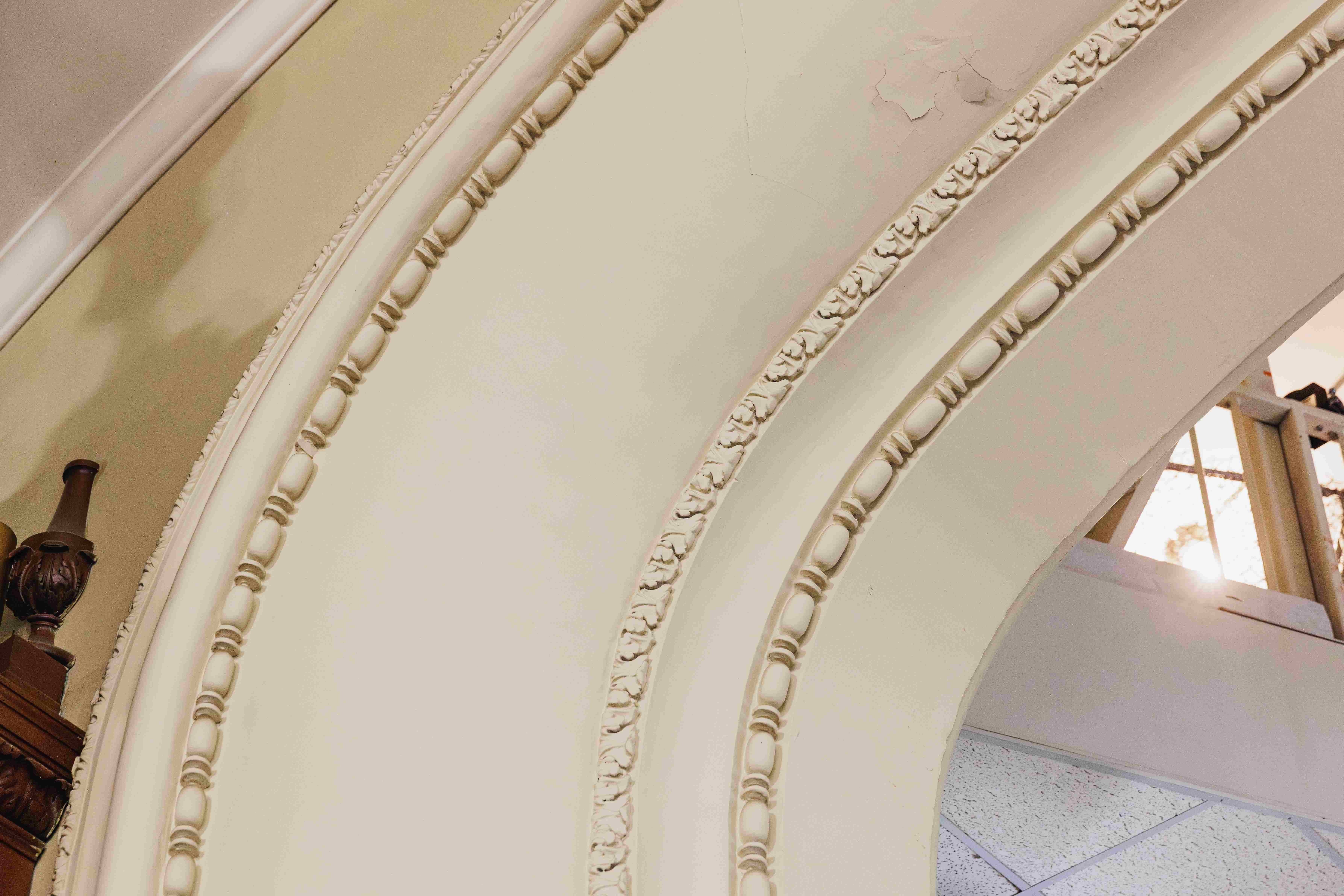 Ornate plaster arch and decorative moulding inside Convocation Hall at the University of Alberta.